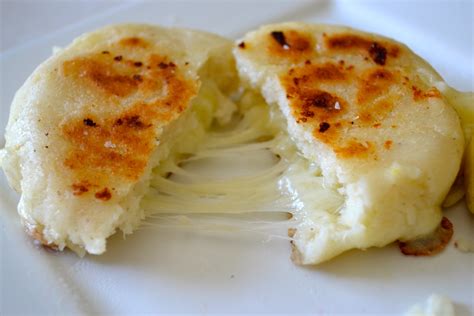  Arepas de Queso:  濃厚なチーズと柔らかな生地のハーモニーが奏でる、カリブ海の風味が口いっぱいに広がるコロンビアの味！